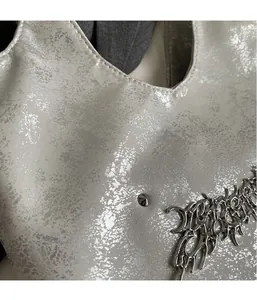 Dettaglio ravvicinato di tessuto metallico grigio chiaro con eleganti finiture in argento
