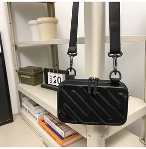 Detail of a mini suitcase bag with black textured stripes and dual zipper closure
