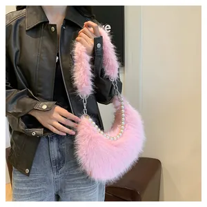 Sac croissant en peluche rose avec chaîne de perles porté sur une personne