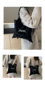 Dettaglio della borsa tote in pelle nera con logo gotico argento e rivetti metallici