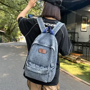 Sac à dos classique en denim bleu délavé avec écusson en cuir porté à l'extérieur