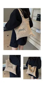 Dettaglio borsa champagne perlata con logo graffiti metallico e borchie argento