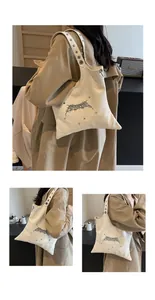 Dettaglio borsa tote crema con borchie argentate e tracolla ampia con occhielli metallici
