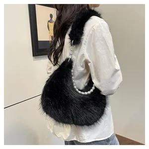 Sac bandoulière en peluche noire avec chaîne de perles et bandoulière douce sur modèle