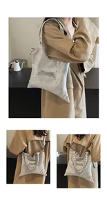 Dettaglio borsa tote argento metallizzato con lettere metalliche stile spine e occhielli