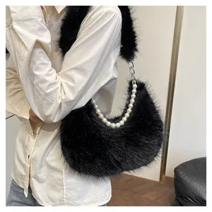 Détail du sac croissant en fausse fourrure noire avec chaîne perlée et bandoulière