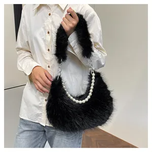 Détail d'un sac bandoulière en peluche noire avec chaîne en perles et métal argenté