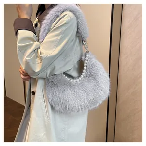 Sac bandoulière chic en fausse fourrure grise avec chaîne en perles sur trench beige