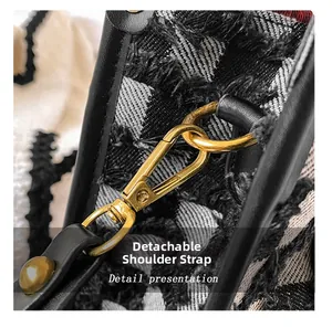 Detail of detachable shoulder strap with gold metal buckle on checkered tote bag