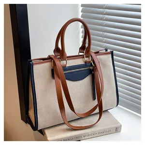 Detailed view of canvas tote bag featuring contrast trim and navy blue zipper pocket