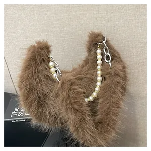 Détail du sac à bandoulière en peluche marron avec perles et bandoulière chaîne argent