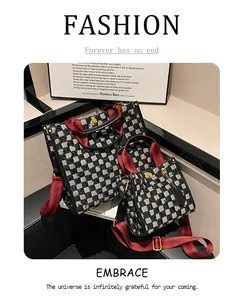 Detail of checkered tweed tote bag set with red striped handles and metal turn-lock