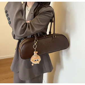 Detail of dark brown Boston bag with embossed logo and sunglasses bear charm