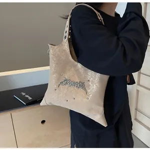 Dettaglio della borsa tote metallica a stella con borchie gotiche e grandi occhielli in metallo