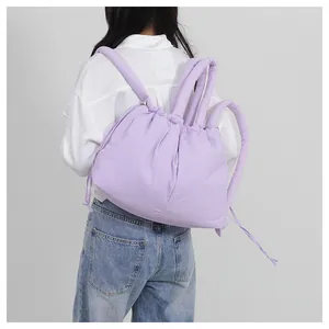 Rear view of lavender quilted puffer backpack with drawstring closure and padded straps