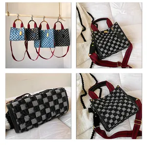 Detail view of denim checkerboard tote bag with red handles and gold hardware accents
