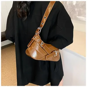 Detail of glossy brown leather shoulder bag with silver hardware and adjustable wide strap