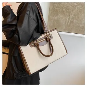 Large beige canvas tote bag with brown leather trim shown on a model for daily commute