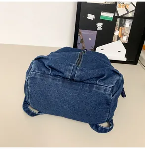 Détail d'un grand sac à dos en jean bleu avec texture épaisse et fermeture à glissière