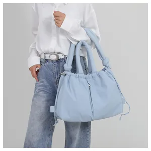 Macro shot of light blue padded nylon bag featuring soft puffy texture and drawstring detail