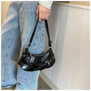 Close-up of black crescent underarm bag with punk silver studs and metal buckle details