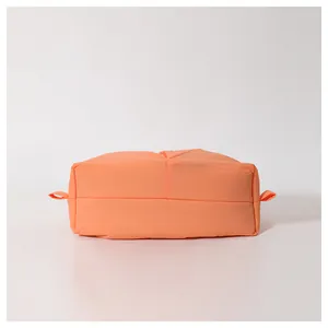 Macro shot of bright orange puffer material and quilted texture on the versatile tote bag