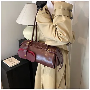 Deep burgundy leather baguette bag with belt buckle details shown on model