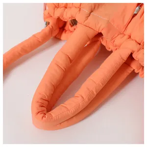 Close-up of orange quilted down handbag featuring soft cloud-like texture and padded handles