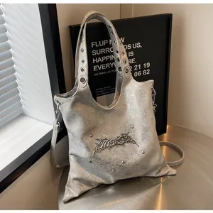 Dettaglio della borsa tote argento metallizzato con texture crackle e logo in metallo