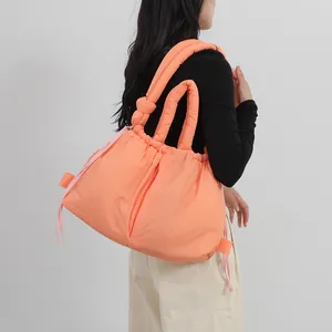 Quilted puffer tote bag in peach orange nylon with drawstring and knotted handle design