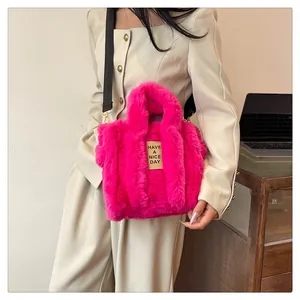 Detail of hot pink faux fur tote bag with adjustable black nylon strap and woven label