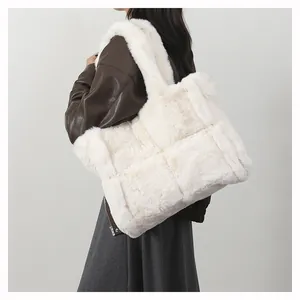 Detail of model wearing a plush white woven faux fur tote bag with a soft texture