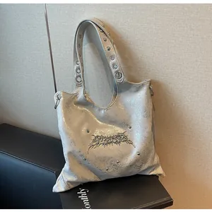 Dettaglio della borsa in pelle argento metallizzato con borchie e decori stile gotico