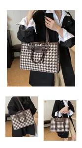 Detail showing houndstooth tote bag with brown faux leather handles and front zip pocket