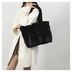 Large capacity black faux fur shoulder bag worn with a white coat in an indoor setting