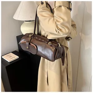 Detail of deep brown leather Boston bag with metal eyelet strap and side flap pocket
