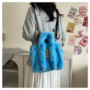 Detail of bright blue plush tote bag with detachable strap and Have a Nice Day tag