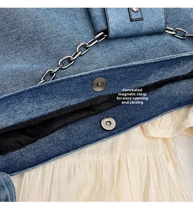 Detailed close-up of the invisible magnetic buckle on blue denim tote bag for easy closure
