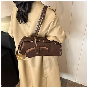 Detail of vintage dark brown faux leather shoulder bag with metallic buckle hardware
