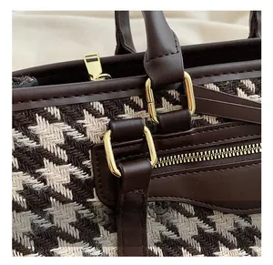 Close-up of golden hardware and woven texture on a large capacity tote shoulder bag