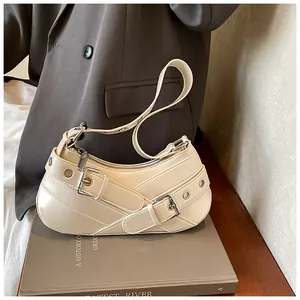 Detail view of cream underarm bag with belt buckle decor and silver hardware