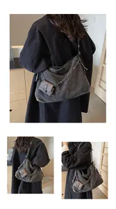 Detailed view of gray washed denim hobo bag with metal chain and mini pouch attachment