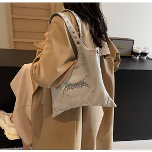 Dettaglio borsa hobo argento con texture metallica crepata, occhielli e rivetti