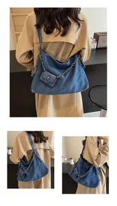 Detail of blue denim hobo bag with silver chain and matching mini pouch attachment