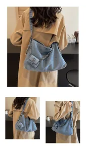Detailed view of large denim tote bag with silver chain and matching mini pouch