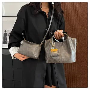 Detail of vintage metallic gray tote and crossbody bag set with elegant gold hardware