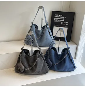 Detailed view of large denim hobo bags in light blue, dark blue, and charcoal grey