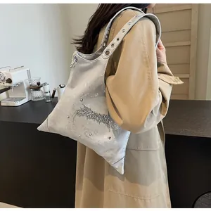 Dettaglio borsa a tracolla argento metallizzato con rivetti e decorazione metallica