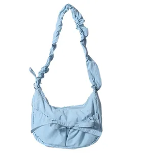 Light blue nylon crossbody bag with ruffled strap and bow detail for casual fashion
