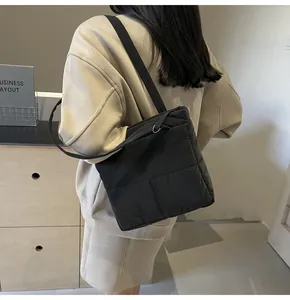 Detail of black quilted shoulder bag featuring premium stitching and silver metal hardware